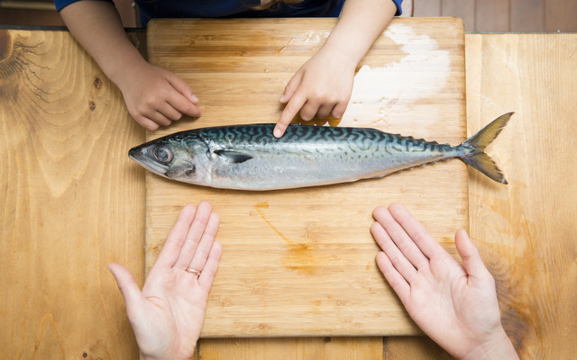 魚を調理する親子